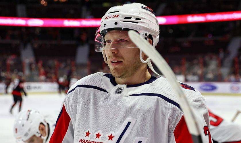 Washington Capitals player Lars Eller in full uniform during a game, wearing a white jersey and helmet.
