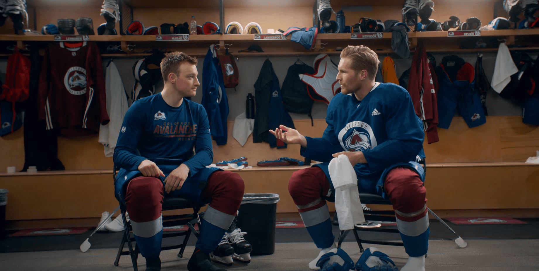 Cale Makar & Gabriel Landeskog in Avalanche gear talking in a change room