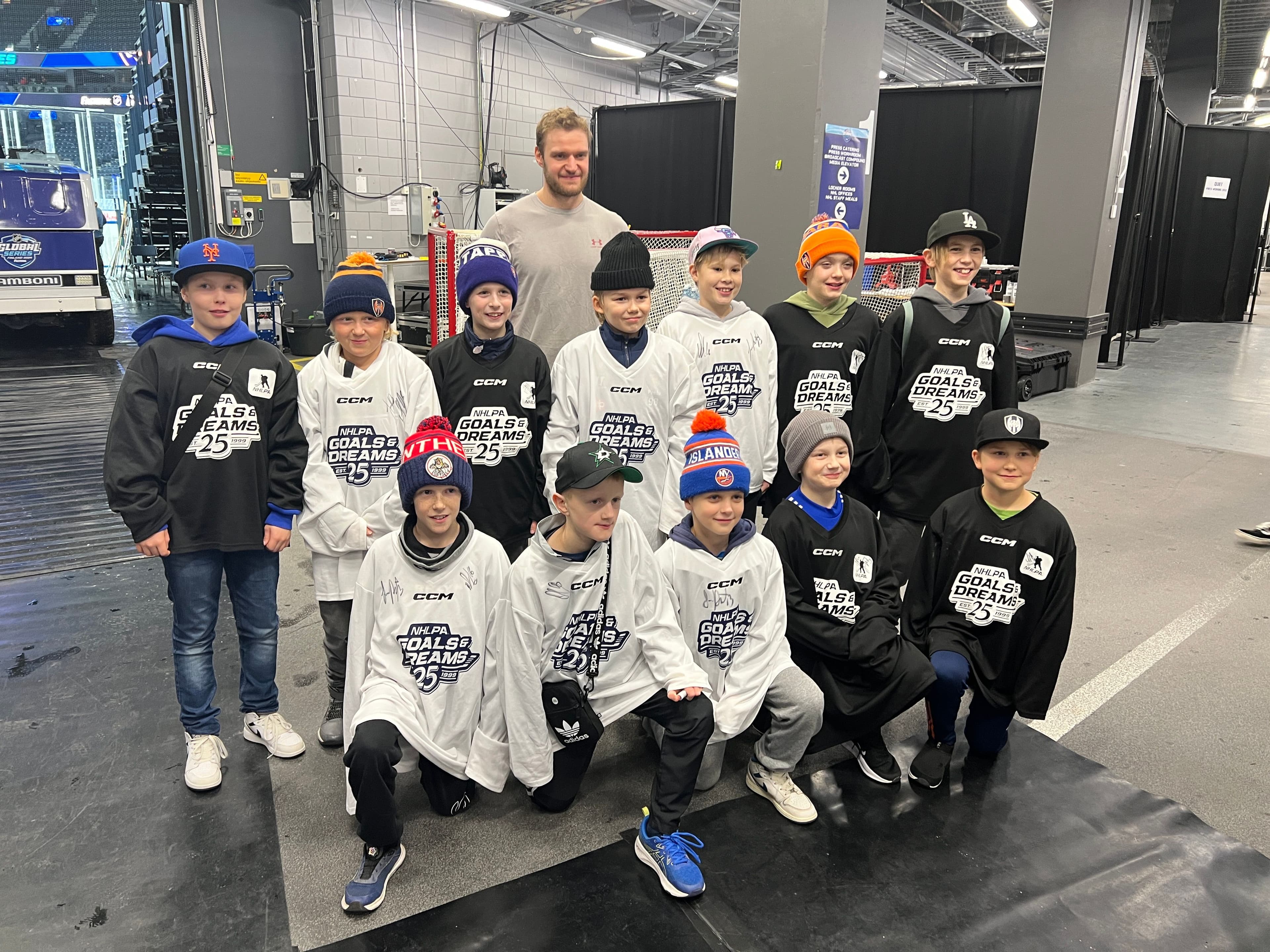 NHL Player standing with young ice hockey players Goals & Dreams organization